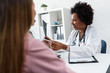 © lordn - Doctor talking with patient at desk in medical office. Health care concept, medical insurance. Womens health.