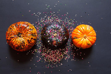 Wall Mural - Decorative pumpkins and glitter, festive Halloween composition on a black background.Flat lay