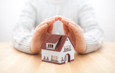 Wall Mural - House miniature covered by hands 