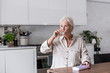 © ReeldealHD images - Mature adult woman taking medicine at home in the kitchen