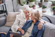 © ReeldealHD images - Mature lesbian couple looking at digital tablet together on sofa