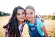 © Halfpoint - Two school children standing on field trip in nature, looking at camera.