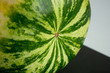 Close up shot of big round green striped watermelon on table