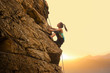 © Maksym Protsenko - Beautiful Woman Climbing on the Rock at Foggy Sunset in the Mountains. Adventure and Extreme Sport Concept