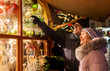 © Syda Productions - shopping, winter holidays and people concept - happy senior couple at christmas market souvenir shop window on town hall square in tallinn, estonia