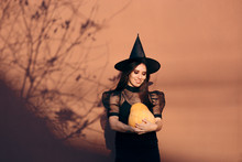 Halloween Woman In Witch Costume Holding Pumpkin