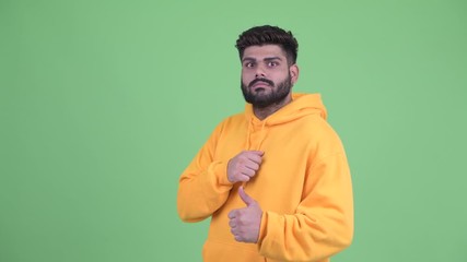 Wall Mural - Happy young overweight bearded Indian man giving thumbs up