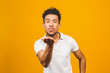 Afro american man over isolated yellow background looking at the camera blowing a kiss with hand on air being lovely and sexy. Love expression.