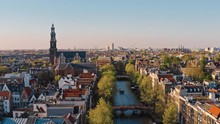 Amsterdam, Netherlands: Drone View Of Westerkerk Church And Narrow Canal With Bridges And Boats Traffic
