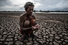 An Elderly Man Sitting In Touch With Rain In The Dry Season, Global Warming, Selection Focus
