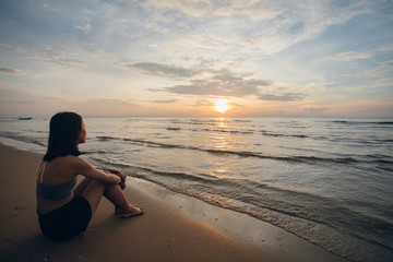 Wall Mural - Rear view of woman looking at the sea during the sunset on the beach