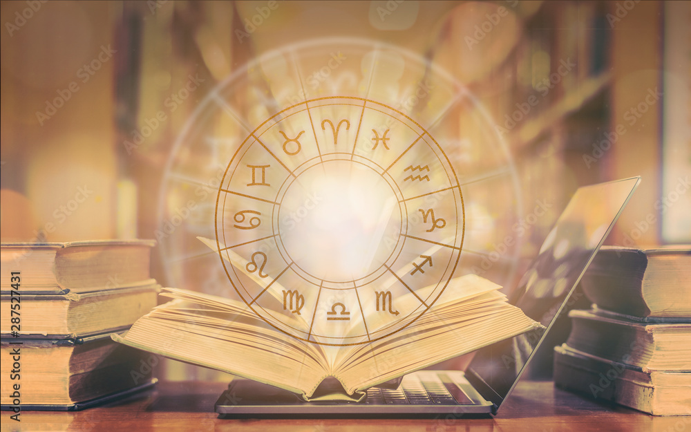 Online horoscope astrology and constellation study with zodiac sign for foretell and fortune telling education course concept with horoscopic wheel over old book and computer laptop in school library - obrazy, fototapety, plakaty 