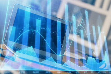 Stock market graph on background with desk and personal computer. Multi exposure. Concept of financial analysis.