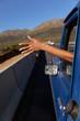 © Wavebreak Media - Young woman sticking her arm out of pick-up truck on highway