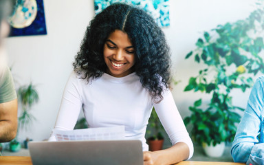 Wall Mural - Beautiful young african woman in office. Modern happy start up team in casual clothes in office or co-working space are working and discussion them plans and ideas.