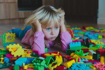 Wall Mural - sad little girl, stress, exhaustion with toys scattered around