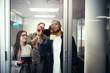 © StratfordProductions - Office colleagues discussing business ideas and plans on a transparent glass door