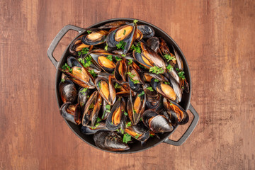 Wall Mural - Marinara mussels, moules mariniere, cooked in a cooking pan, shot from above on a dark rustic background