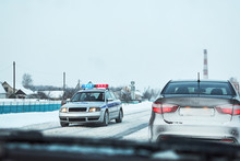 Police Car With Red And Blue Flshaer Lights Stopped Car On Winter Snowy Road