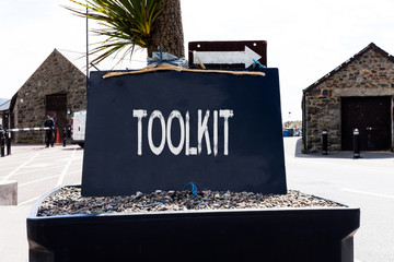 Text sign showing Toolkit. Business photo showcasing set of tools kept in a bag or box and used for a particular purpose Empty black board with copy space for advertising. Blank dark board