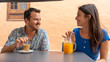 © Baifoworld - Two people flirting in a terrace having a date and smiling with relaxing atmosphere. Married Couple seated drinking a coffee and orange juice having a conversation