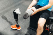 © karrastock - Disabled athlete assembling his leg prosthesis in the gym. Paralympic Sport Concept.