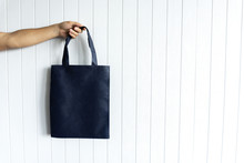 Blank Canvas Dark Blue Tote Bag, Design Mockup With Mans Hand On White Background. No Plastic Concept