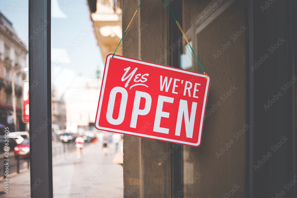 yes we're open sign on the glass of the doors in store.  welcome sign at the store - obrazy, fototapety, plakaty 