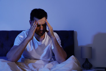 Poster - Sleepy handsome man sitting in dark room at night. Bedtime