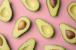 Cut fresh ripe avocados on pink background, flat lay
