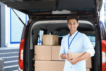 Sticker - Young courier with parcel near delivery car outdoors