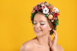 © New Africa - Beautiful young woman wearing Christmas wreath on yellow background