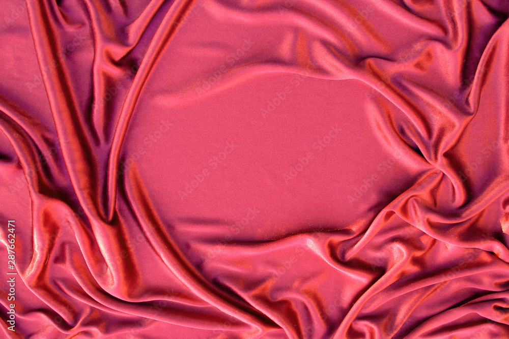 Photograph of silk fabric, beige color. The texture of silk fabric. Luxury silk fabric background with waves and drapery. Background for fashion luxury design, close-up, copy space