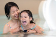 © Kenishirotie - Happy mother and baby daughter at indoor swimming pool