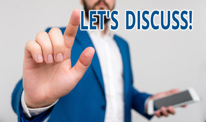 Conceptual hand writing showing Let S Discuss. Concept meaning asking someone to talk about something with demonstrating or showing Businessman pointing with pen in empty copy space