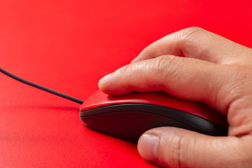 man using a red mouse on red background