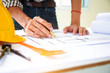 © weerachai - Hand engineers are writing home construction designs to bring them to prospective customers.