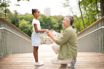 Wall Mural - Cheerful daughter smiling while speaking with daddy