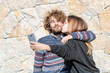 © Noble Nature - Jeune couple prenant un selfie avec leur smartphone en se faisant un bisou - jeune couple heureux et souriant