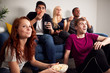 © Monkey Business - Group Of College Students In Shared House Watching TV And Eating Popcorn