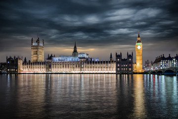 Fototapete - Der Westminster Palast in London mit Regierungssitz und Parlament bei Nacht mit starker Bewölkung, Großbritannien