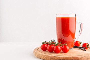 Wall Mural - Fresh Tomato juice in a Cup on a wooden tray with cherry tomatoes