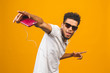 © denis_vermenko - Portrait of a happy young african american man listening to music with headphones and dancing isolated over yellow background.