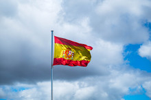 National Spanish Flag In Blue Sky With Clouds Spain