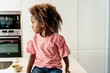 © Westend61 - Girl sitting on kitchen counter looking sideways