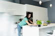 © Westend61 - Woman using laptop in kitchen