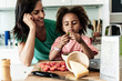© Westend61 - Happy mother and daughter cooking in kitchen together