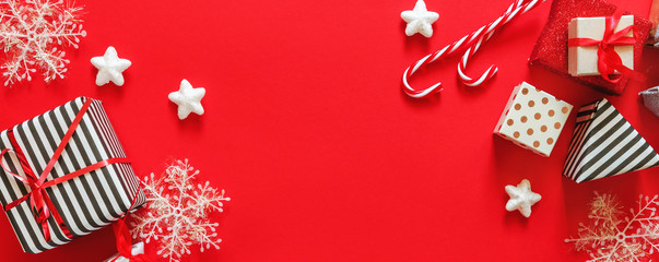 Wall Mural - Christmas flat lay top view, gifts in different wrappers boxes on a red background, festive decor copy space