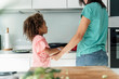 © Westend61 - Mother and daughter cooking in kitchen together