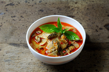 Coconut Milk Curry with bamboo shoot and green mussel in bowl on wood table